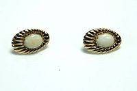 Pair of oval 14K gold earrings with opal center stones shown on white background from the front.
