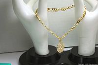 Photo showing the full gold tone Figaro chain ankle bracelet with extension and hanging Leo zodiac charm on white hand display.