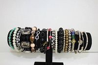 Full display of all elastic bracelets on black velvet stand, showing variety in bead sizes, colors, and styles.