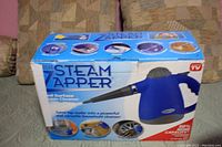 Original product box of the Steam Zapper showing front with product name and use images.