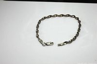 Full view of the 7-inch twisted design sterling silver bracelet with lobster clasp, laid flat on a white surface.
