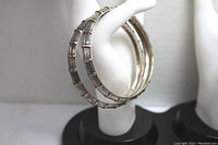Side view of two sterling silver bangle bracelets showing textured bamboo-inspired design and patina.