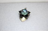 Front view of handmade spoon flower pendant on gray background
