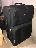 Front and side view of large black wheeled suitcase with Seahorse metal logo visible on fabric surface