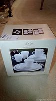 Photo of sealed box with front image showing four white mugs and plates from the Lenox Tin Can Alley Four collection.