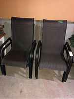 Front view of two mesh sling patio chairs with black frames