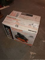 Box showing Ridgid WD4070 vacuum model and specifications including 4-gallon capacity, portable vac.