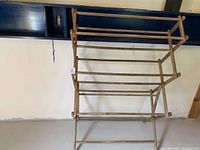 Full view of the assembled antique wooden folding drying rack showing multiple rods and foldable frame.