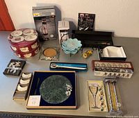 Top view photo showing entire lot displayed on table including marble cheese plate, place card holders, appetizer plates, boxed wine aerator, vintage ice mallet, cocktail shaker, and various wine accessories.