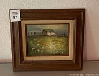 Front view of framed painting showing entire artwork and frame, including hanging hook and auction tag.