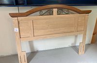 Front view of queen size wooden headboard showing the full width and height with natural wood paneling.