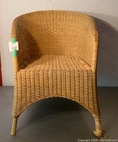 Front view of yellow wicker chair showing full shape and design.