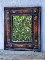 Full frontal image of the square mirror showing the book spine frame and the reflective mirror surface.