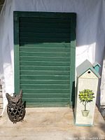 Cast iron owl, green shutter and display cabinet shown together for scale and full lot view.