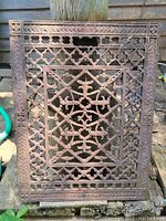Front view of the vintage cast iron floor grate showing detailed metalwork and original finish