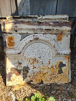 Photo showing stack of vintage Victorian-style embossed tin ceiling tiles with white paint, rust, and decorative patterns.