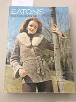 Front cover of Eaton's 1975 Fall and Winter Catalogue showing a woman in a fur collared sweater and blue sky background.