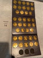 Full view of the three pages of mounted gold-colored president coins with visible portraits and names from George Washington through Warren G. Harding