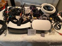 Overview of Lot showing Samsung and Oculus VR headsets in front surrounded by various audio cables including RCA cables with red yellow and white connectors