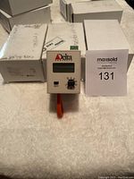 Front view of one pressure sensor showing Delta logo, digital display, and adjustment knob with original boxes in background