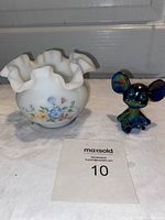 Photo showing the frosted white ruffled bowl with hand painted multi-color floral design alongside the iridescent glass mouse figurine with a maxsold lot card.