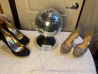 Photo of black pumps, rhinestone Aldo heels, and disco ball on display