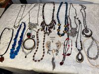 Full view of all 17 pieces spread on white surface showing variety of necklaces, rings, and bracelets.
