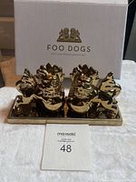 Foo Dogs salt and pepper shakers on their gold rectangular base with original box behind.