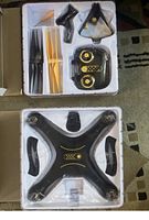 Top view of the drone and accessories in white plastic packaging showing the drone, controller, propellers, propeller guards and screwdriver.