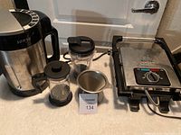 Bella panini maker, Sonya blender juicer grinder, French press, and blender cup displayed on table
