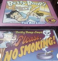 Both Betty Boop vintage metal signs shown together, front view.