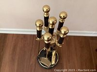 Top view of brass fireplace tool set with black handles and round stone base