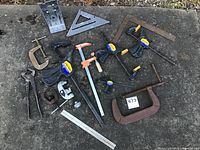 Clamps and measuring tools arranged on surface showing assortment