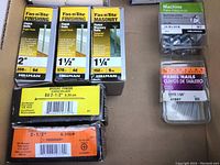 Close-up photo of boxes of nails and fasteners showing sizes, quantities, and brand names.