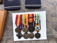 Close-up of five US Air Force medals with ribbons pinned to a white background, showing detailed designs and colors.