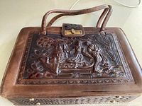 Front view of the vintage brown leather purse showing detailed embossing of a Mayan couple and the clasp closure