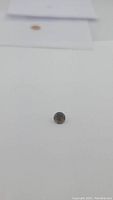Photo showing the small round smokey quartz gemstone on a white background, side angle