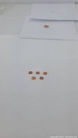 Five natural caramel opals arranged on a white surface showing their deep caramel coloration and rectangular cushion cut shapes.