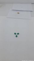 Three vivid lime green oval cabochon onyx gemstones displayed on a white background, arranged in a triangular formation.