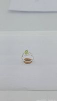 Front angle of the natural peridot 1.25ct sterling silver ring with heart carvings on band.