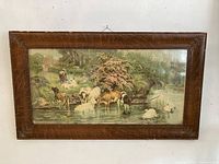 Front view of oak framed countryside print showing multiple cows near a pond and a girl in the background.