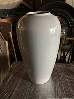 Full front view of a large grey ceramic vase with a smooth, glossy surface and rounded shape.