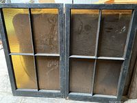 Pair of large vintage black framed windows with amber textured glass panes.