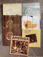 Lot showing six Chicago double album sets with different cover designs and two America albums in front.