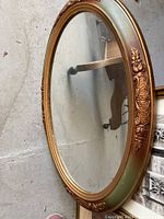 Full view of the vintage oval mirror placed on floor showing the overall size and frame design.