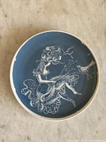 Full view of the vintage Rosenthal plate showing overall design of a seated woman with flowing hair on a blue background.