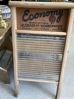 Front view showing the entire wooden frame washboard with the printed logo and metal ridged panel.