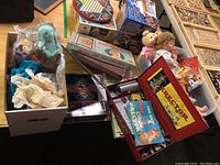 Lot overview showing board games, dolls, Erector set in red box with parts, and various toys.