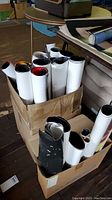 Two cardboard boxes filled with various rolled movie posters showing the lot contents and storage condition.