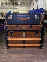 Stacked vintage trunk and suitcase showing front view with latches and locks